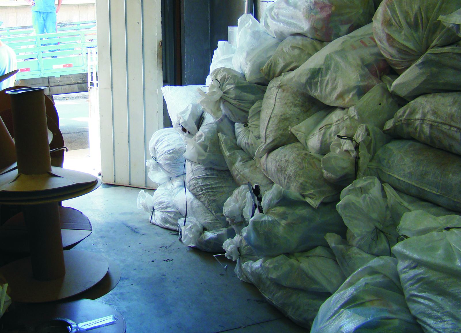 Fardos de aparas de papel e resíduos separados para reciclagem no galpão da Arte Criação
